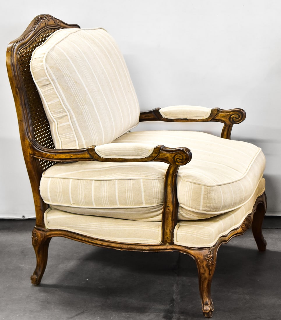 CONTEMPORARY LOUIS XV STYLE BERGERE ARMCHAIR: A contemporary Louis XV style Bergere armchair with caned back and striped ivory upholstery.