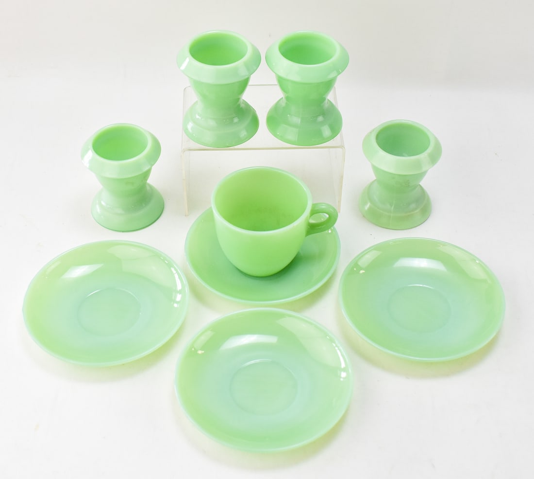 COLLECTION OF JADEITE GLASSWARE: A collection of jadeite glassware including four large egg cups, one mug, and four Fire king oven glass saucers measuring 6 inches in diameter.