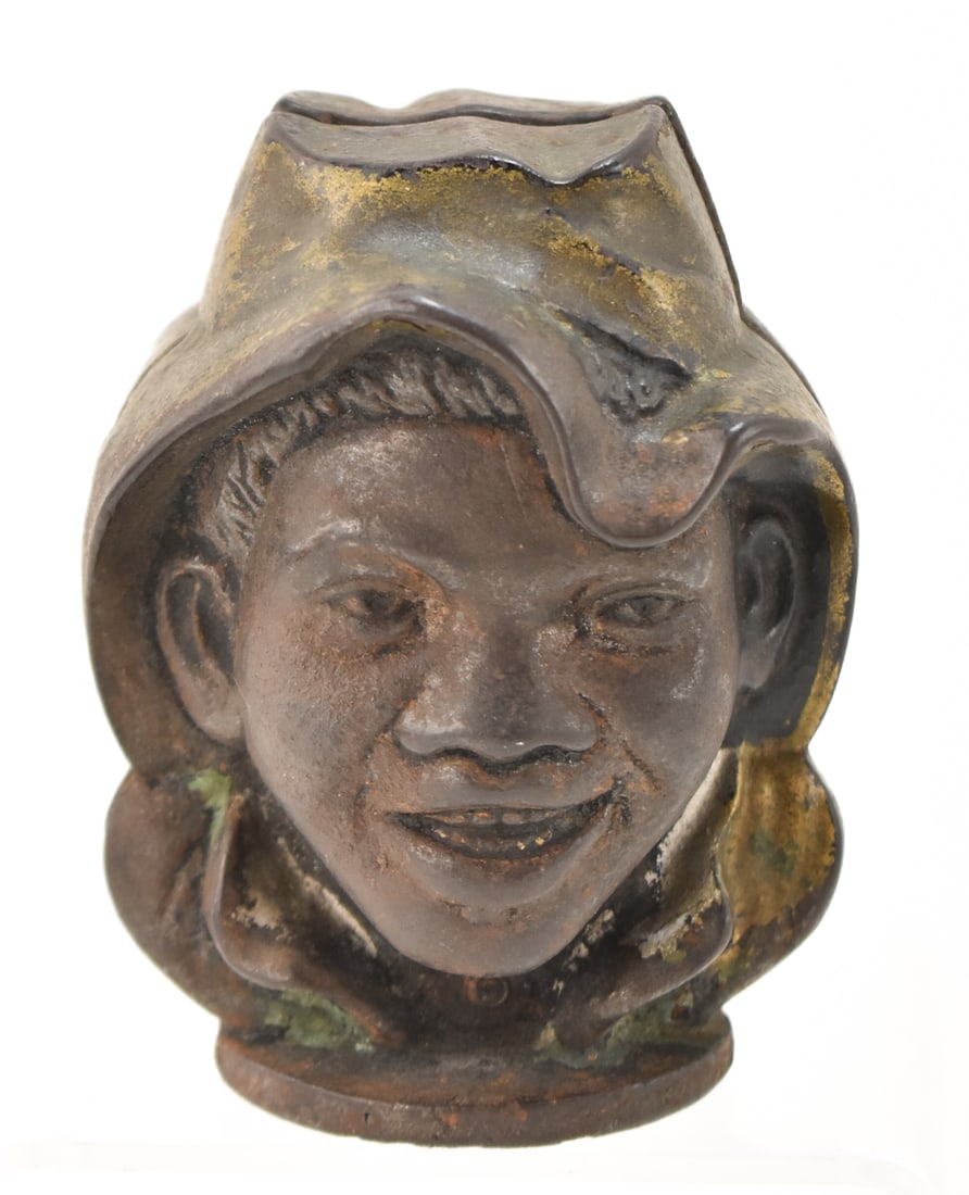 TWO-FACED CAST IRON COIN BANK: A two-faced cast iron coin bank with gilt paint decoration, measuring about 4 inches in height.