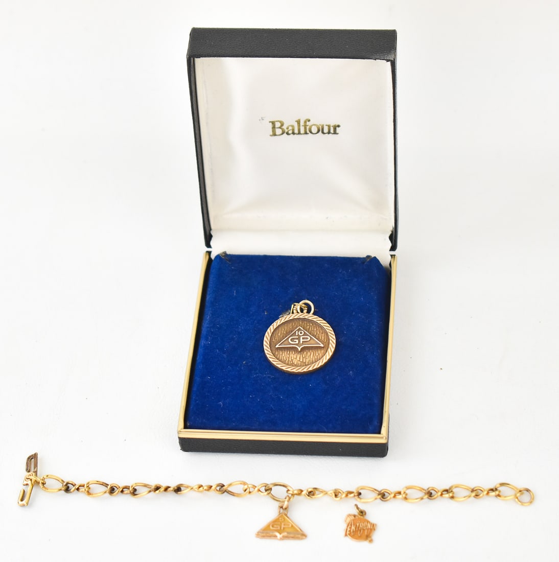 GOLD & GOLD-FILLED COMPANY CHARMS & BRACELET: An assortment of gold and gold-filled charms from companies Georgia Pacific and Tektronix. A large 10K Gold-Filled Georgia Pacific charm, and a 12k Gold-Filled charm bracelet with a 10K Gold Tektronix