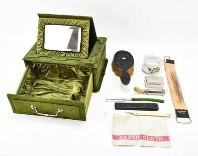 VICTORIAN VELVET SHAVING BOX WITH GROOMING ACCESSORIES: Victorian green velvet shaving box with grooming accessories that includes, two straight razors handle, a carved ebonized wood hair brush, porcelain shaving mug, silver lidded tin, silver shaving brus