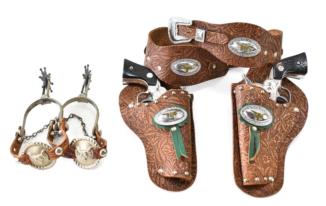 PAIR OF NICHOLS STALLION REVOLVER .32 CAP GUNS: A pair of Nichols Stallion .32 revolver cap guns made in the USA in the late 1950s, with a double holster and spurs.