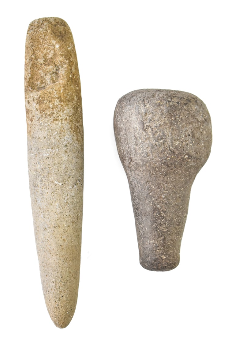TWO STONE GRINDING PESTLES: Two pre-1900 stone grinding pestles, measuring 10" H x 2" W x 2" D, and 6" H x 3" W x 3" D.