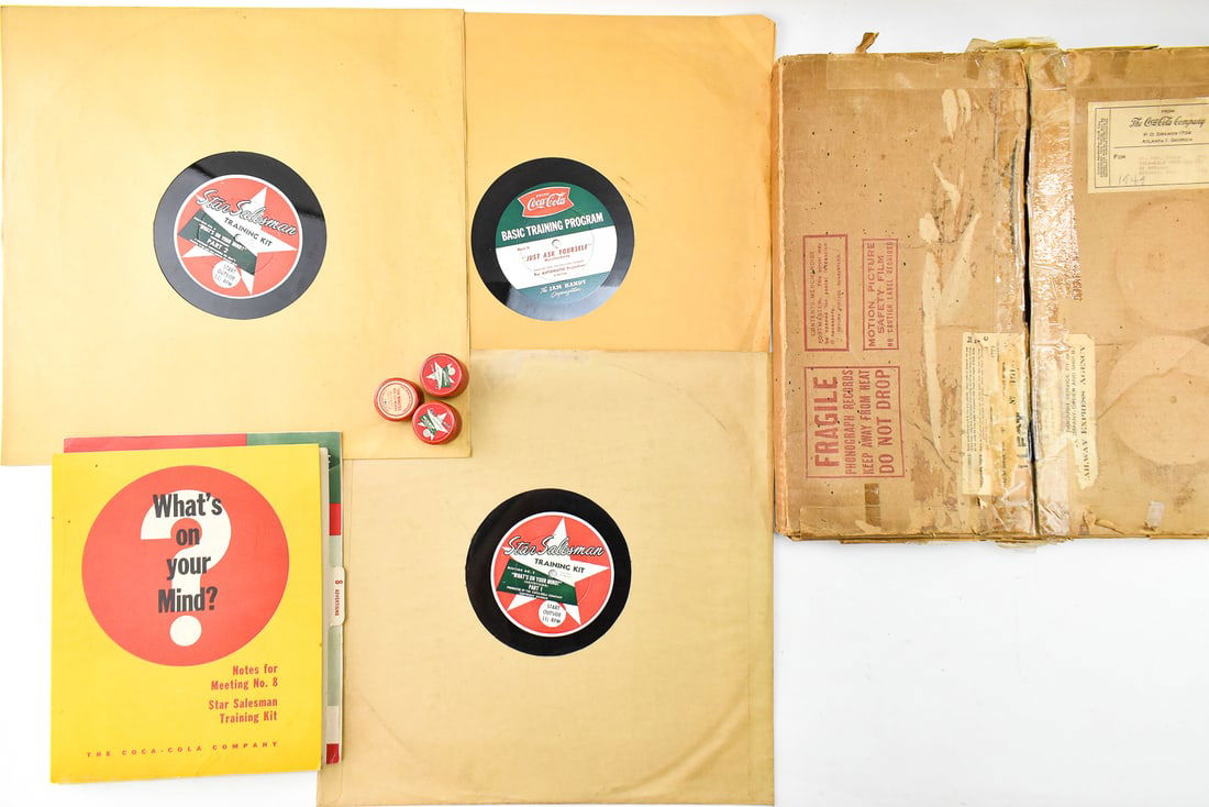 1949 COCA-COLA SALESMAN TRAINING MATERIALS: Circa 1949 salesman's training materials for Coca-Cola include three film canisters with strips, three large 33 1/3 vinyl records, a "What's on Your Mind" meeting leader training booklet, and a "basic