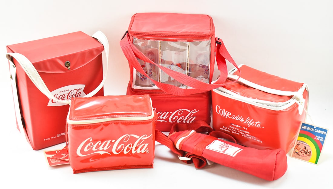 COLLECTION OF INSULATED COCA-COLA COOLERS: Five Coca-Cola brand insulated lunch and drink bags include three lunch cooler bags, a 12" H x 9" W x 6" D cooler bag with original glasses, and Hebrew insulated drink carrier.