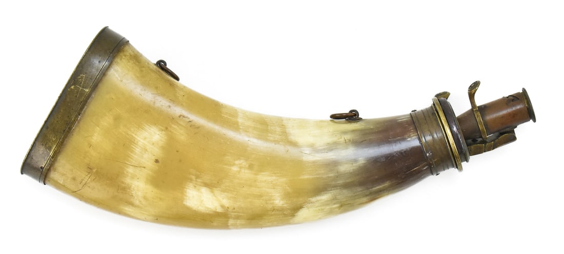 FLATTENED COW HORN CONTINENTAL HUNTING POWDER FLASK: A flattened cow horn continental hunting powder flask with brass mounts, circa early 20th century. The flask measures 9" long.