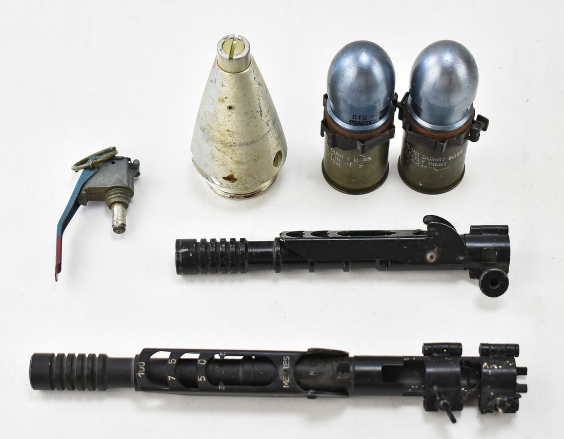 ASSORTED MILITARY GRENADIER COLLECTIBLES: This lot includes a pair of inert CTG 40mm M385 grenade launcher dummy/practice rounds, an inert intact XM228 hand-grenade fuse, a Mecar post-WWII grenade launcher attachment for K98s and other rifles
