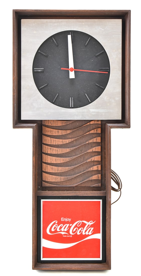 COCA-COLA BENCO NEW OLD STOCK ELECTRIC WALL CLOCK: A circa 1970s new old stock Coca-Cola electric light-up wall clock with faux wood grain with original box display, measuring 26.5" H x 12" W x 2.5" D.