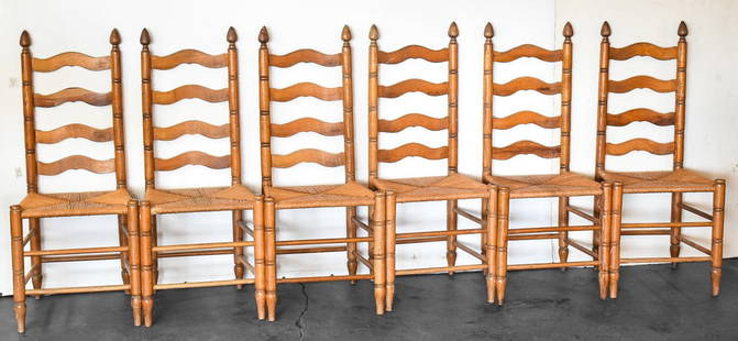 SIX ANTIQUE LADDER BACK CHAIRS: Six antique ladder back oak chairs with rush seats. Each chair measures 42.5" H x 18" W x 16" D.