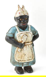 BLACK AMERICANA CAST IRON AUNT JEMIMA COIN BANK: A circa 1920s "Aunt Jemima" cast iron coin bank measuring 12" H x 7" W x 4" D.