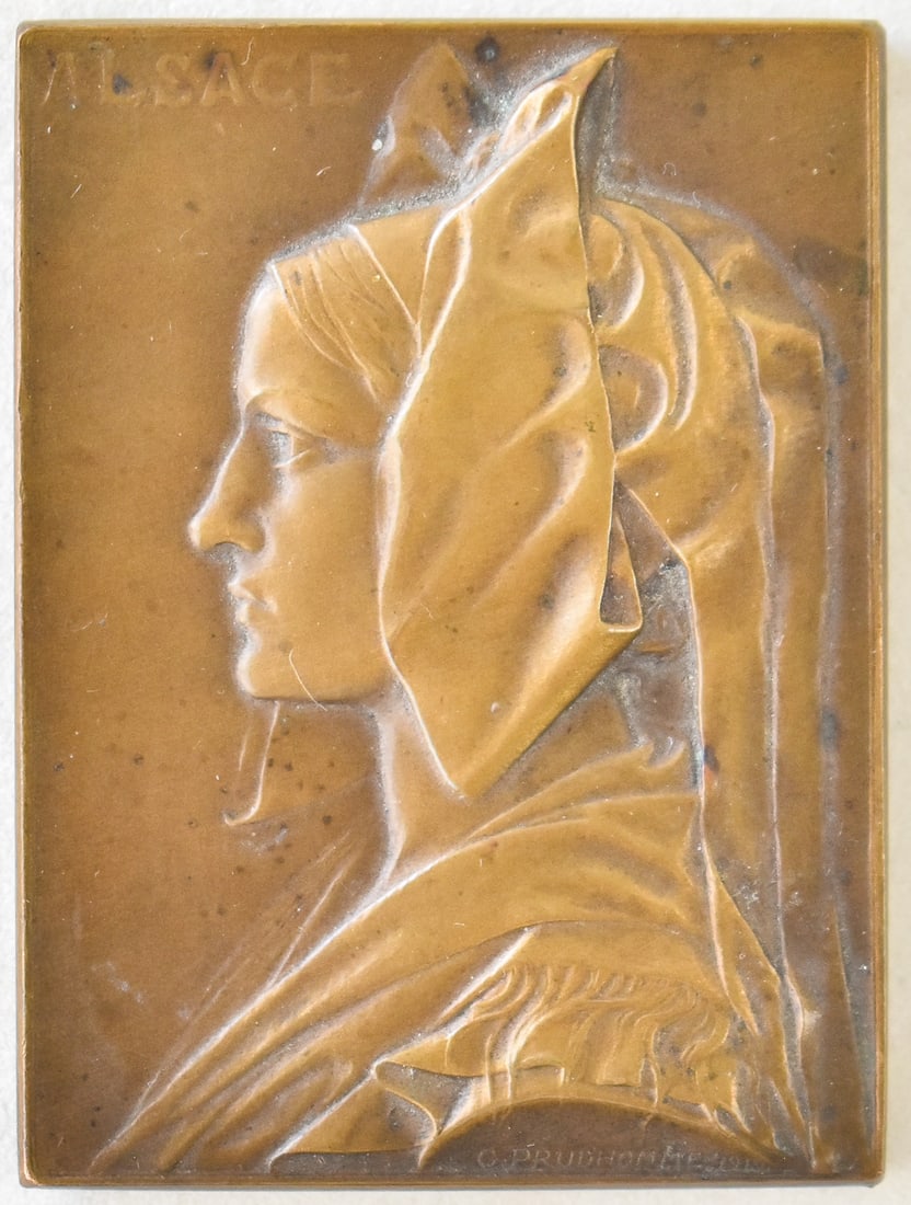 1919 GEORGES-HENRI PRUD'HOMME BRONZE 'ALSACE' PLAQUETTE: A 1919 signed Georges-Henri Prud'homme (1873-1947) bronze marked "Alsace" commemorative plaquette. The item measures 1" H, 2" W, 3" D.