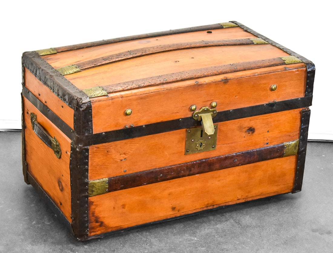 C. 1870 DOME-TOP TRAVEL TRUNK: A c. 1870 dome-top travel trunk with an internal divider and hammered metal hardware. The trunk measures 30" L x 17" W x 18" H.