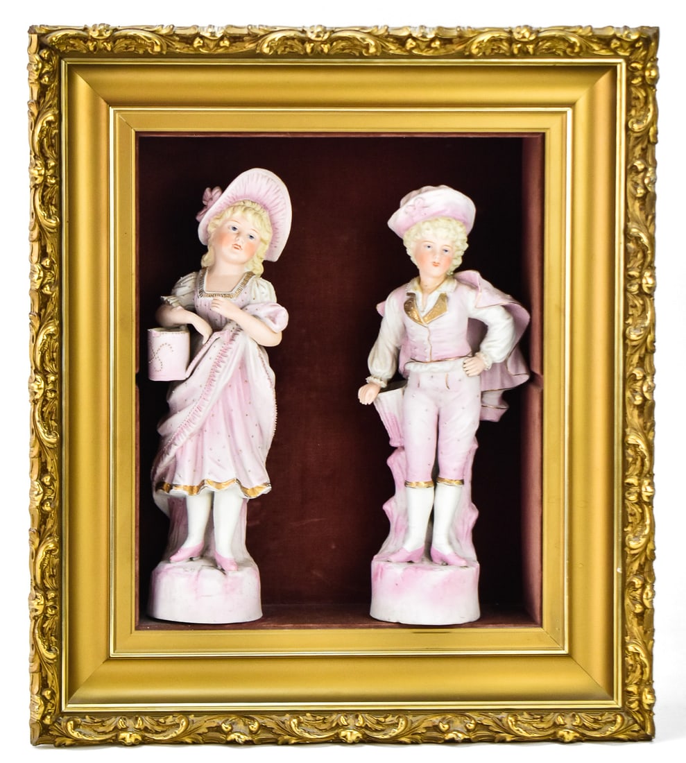 VICTORIAN BISQUE PORCELAIN FIGURES IN SHADOWBOX: Two late 19th century 15" H bisque porcelain figures of a boy and girl presented in an open shadowbox measuring 23.5" H x 20.5" W x 6.5" D.