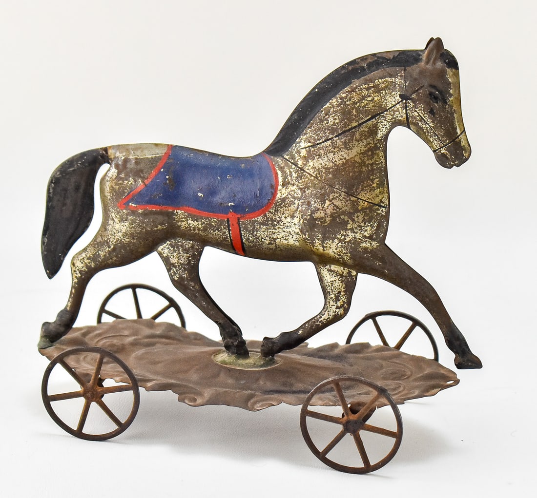 VICTORIAN TIN HORSE PULL TOY: A children's tin horse pull toy, circa late 19th century. The item measures 7.5" H, 9" W, 4" D.