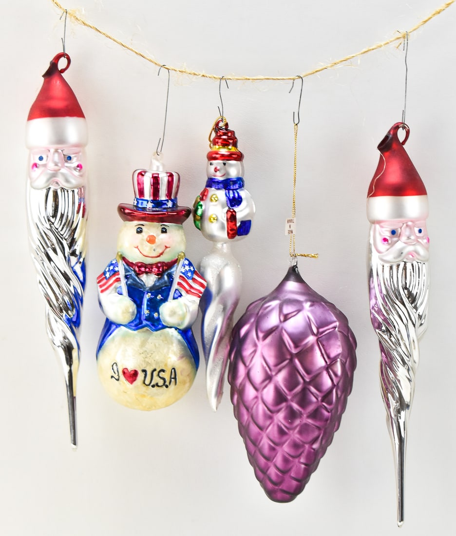 VINTAGE CHRISTMAS ORNAMENTS: DEPARTMENT 56 & RUSS BERRIE: This lot includes the following vintage Christmas ornaments: Department 56 patriotic snowman, two Santa Claus icicles, one Russ Berrie & Company snowman icicle, and one purple pinecone. The larges