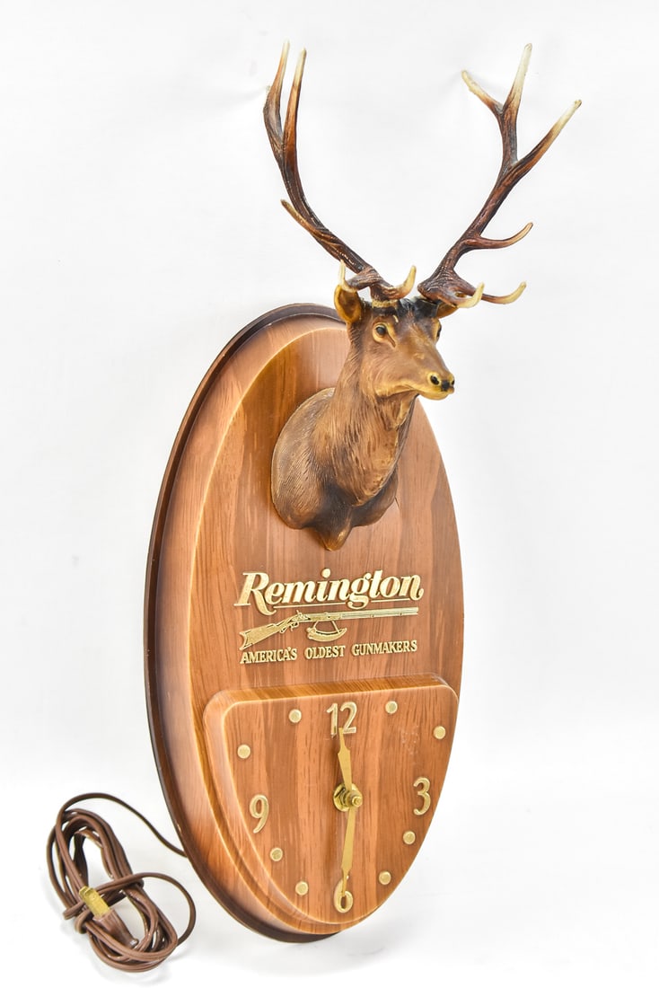 1960s REMINGTON ADVERTISING WALL CLOCK: A 1960s Remington Arms plastic case electric wall clock with elk head, measuring 19" H x 8" W x 6" D.
