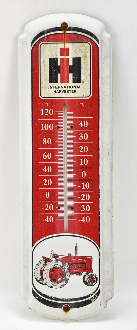 INTERNATIONAL HARVESTER ADVERTISING WALL THERMOMETER: A vintage painted metal International Harvester advertising wall thermometer, measuring 27" H x 8.5" W x 1.5" D.