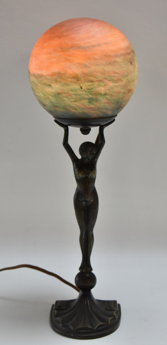 ART DECO FIGURAL TABLE LAMP: An Art Deco style table lamp with nude lady holding an art glass globe shade, measuring 17" x 6" W x 6" D.