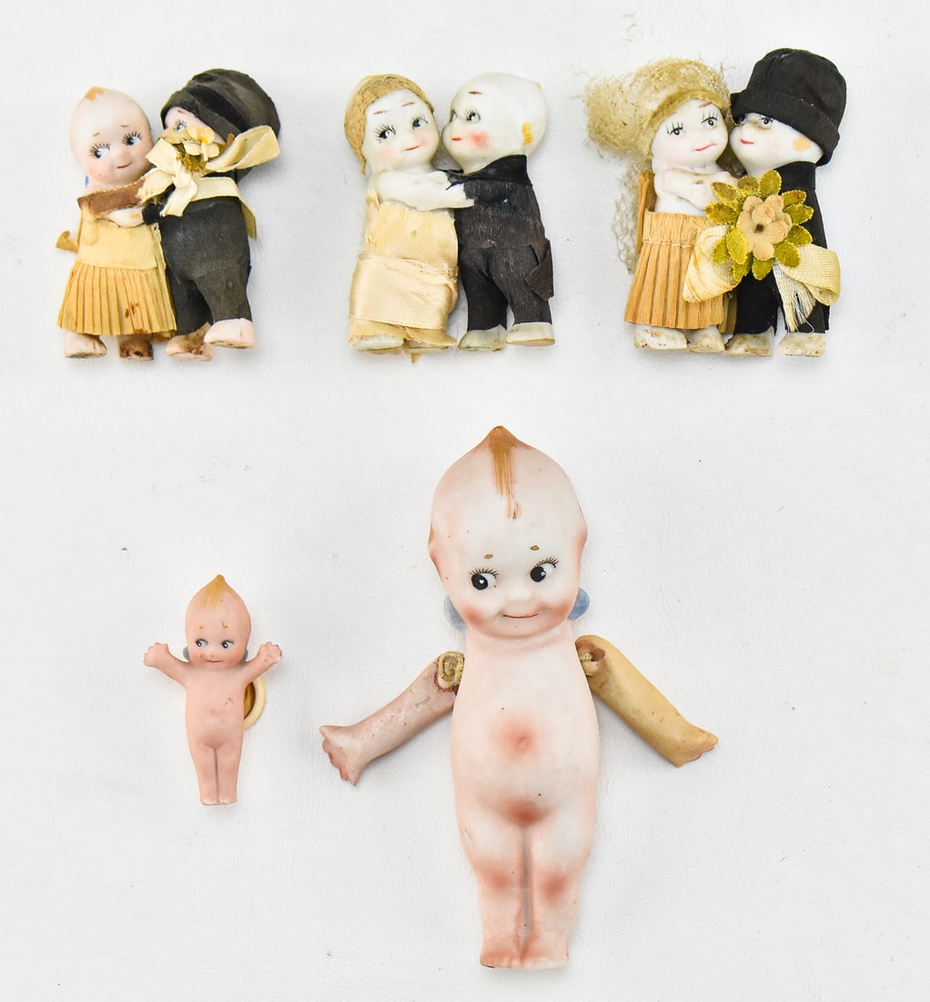 ROSE O'NEILL KEWPIE HUGGER DOLLS & MORE: Includes three circa 1910-1920s Rose O' Neill kewpie "Hugger" wedding cake topper dolls, a bisque kewpie doll marked "Nippon" measuring 4.5" H x 2" W x 1" D, and a bisque kewpie designed to button int