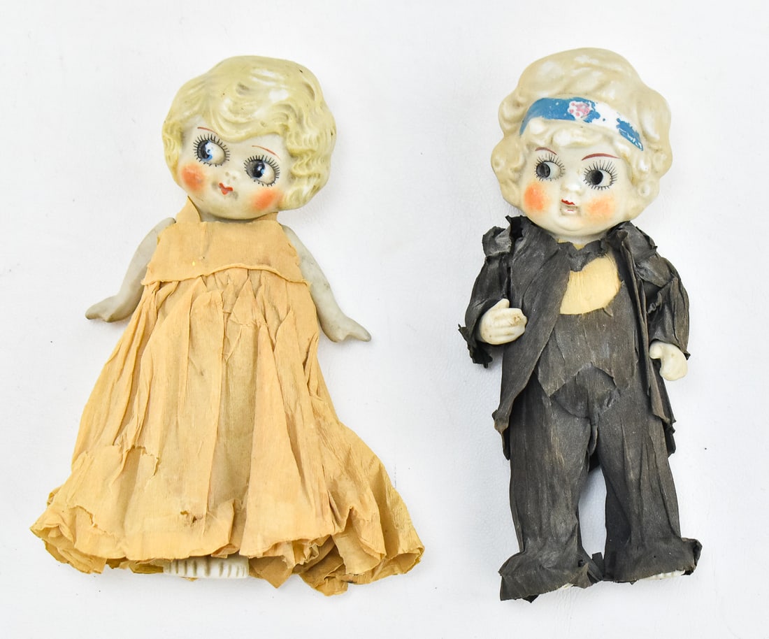 MADE IN JAPAN DOLL BRIDE & GROOM WEDDING CAKE TOPPERS: A pair of 1920s-30s made in Japan wedding cake topper bisque dolls with crepe paper clothing. Each measures approximately 6" H x 3" W x 2" D.