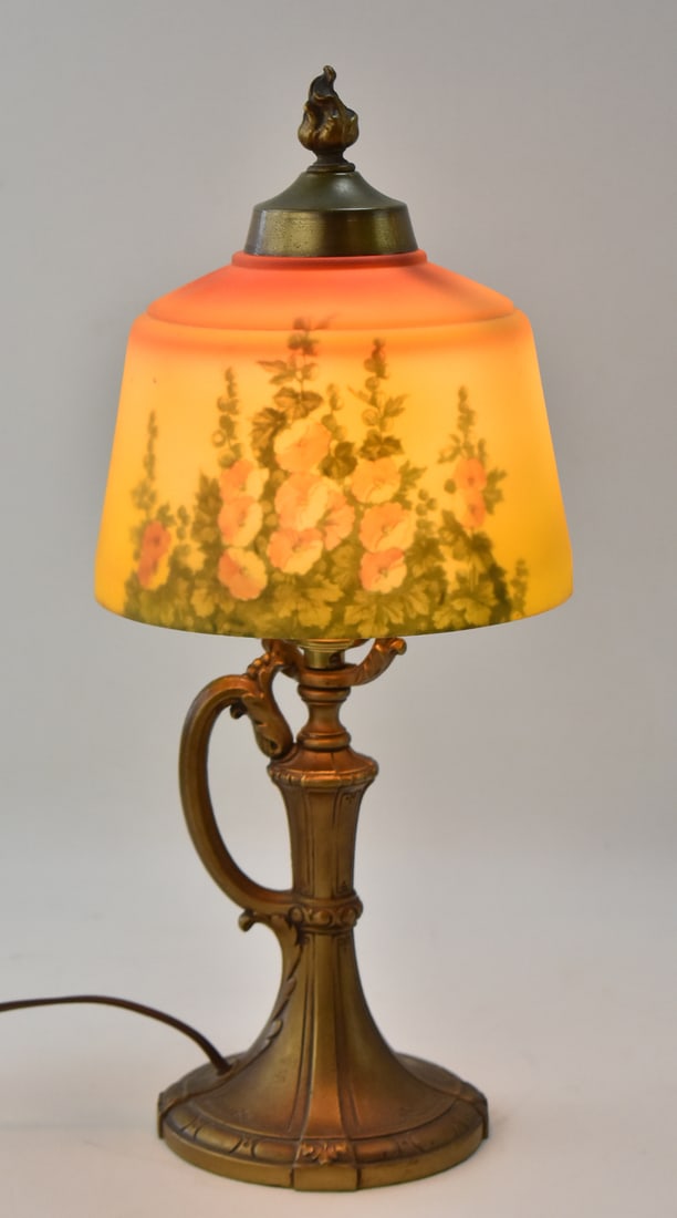 LIGHTOLIER REVERSE-PAINTED GLASS BOUDOIR LAMP: A Lightolier reverse floral painted glass boudoir lamp with a handled base, circa 1920s. The lamp measures 16" H, 7" W, 7" D.