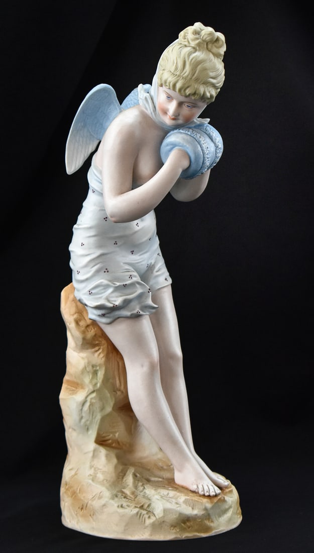RUDOLSTADT BISQUE PORCELAIN ANGEL: A Rudolstadt bisque porcelain angel wearing muffs and is marked "833 19" "38", circa early 20th century. The item measures 15.5" H, 6" W, 5" D.