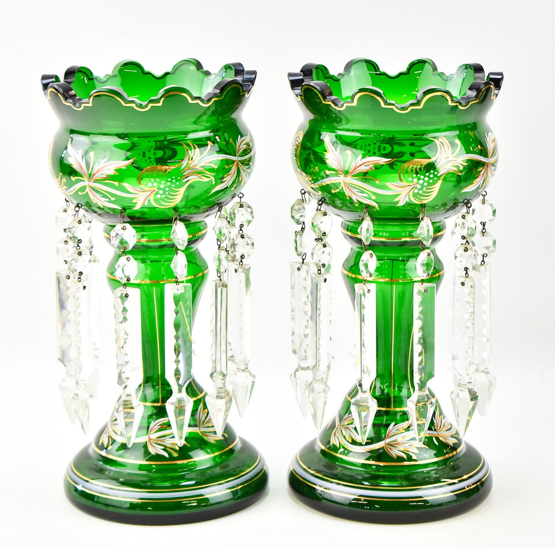 BOHEMIAN EMERALD GLASS LUSTRE PAIR, EARLY 20TH CENTURY: A pair of Bohemian emerald glass lustres featuring gilt foliage patterning and glass spear prisms, circa early 20th century. The item measures 13" H, 6.5" W, 6.5" D.