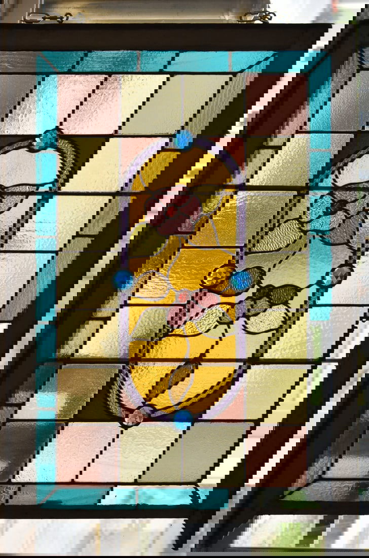 POVEY BROTHERS (ATTR.) STAINED GLASS WINDOW FRAME: A Povey Brothers - Portland, Oregon (attributed) textured stained glass window featuring a dogwood blossom, jewel accents, and vertical hanging hardware, measuring 50" H x 30" W x 1.5" D.