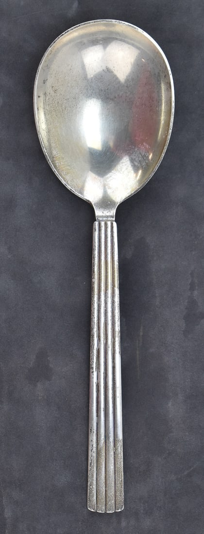 BERNADOTTE PATTERN STERLING SILVER SPOON, GEORG JENSEN: A Bernodotte pattern sterling silver serving spoon made by Georg Jensen of Denmark, circa 1939. At the base of the handle, the spoon is marked with the Georg Jensen maker mark and "STERLING DENMARK".