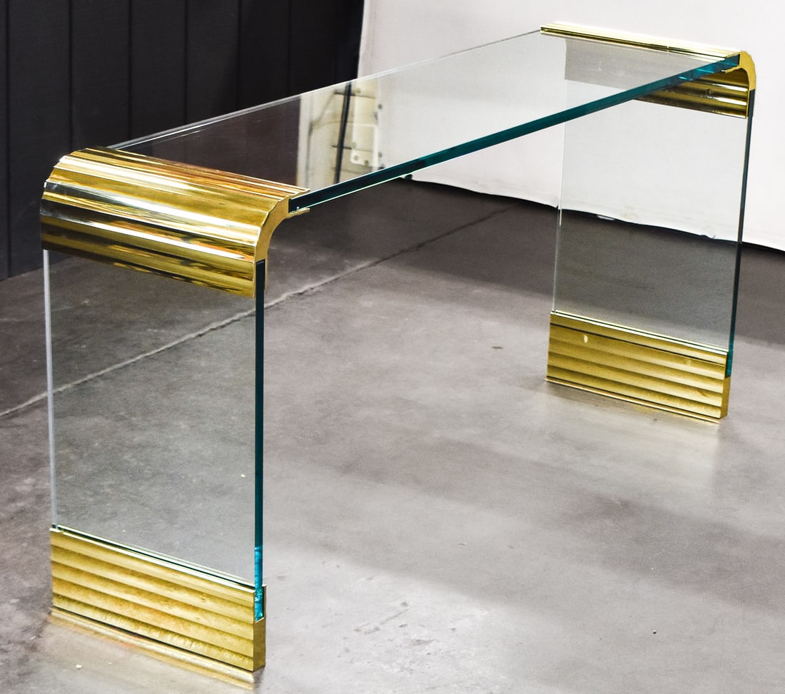 LEON ROSEN FOR PACE MCM GLASS AND BRASS WATERFALL CONSOLE TABLE, C. 1970s: A Mid-century Modern glass and brass plated waterfall design console table by Leon Rosen for the Pace Collection, circa 1970s. The console table is a three-piece construction with thick glass and bras