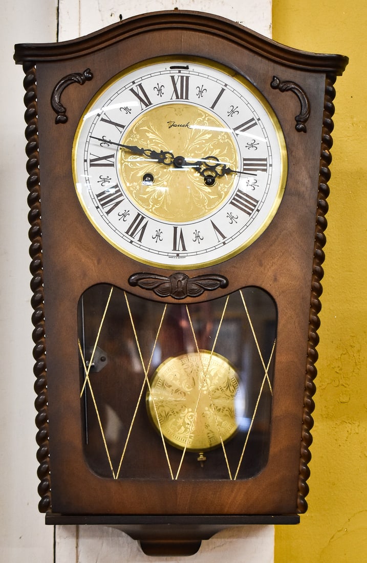 JAUCH WEST GERMAN CHIME TRAPEZOID WALL CLOCK: A Jauch - West Germany chime trapezoid wall clock with a key and pendulum, circa 1950-1960s. The item measures 19.5" H, 12.5" W, 5" D.