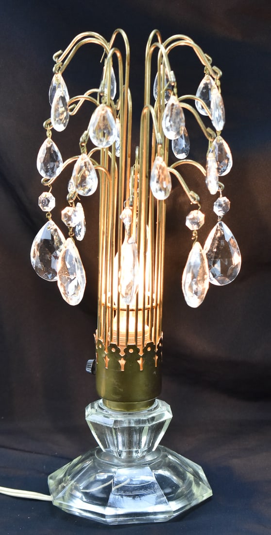 HOLLYWOOD REGENCY WATERFALL TABLE LAMP: A vintage Hollywood Regency waterfall table lamp with dangling crystal prisms and glass base, measuring 15" H x 6" W x 6" D.