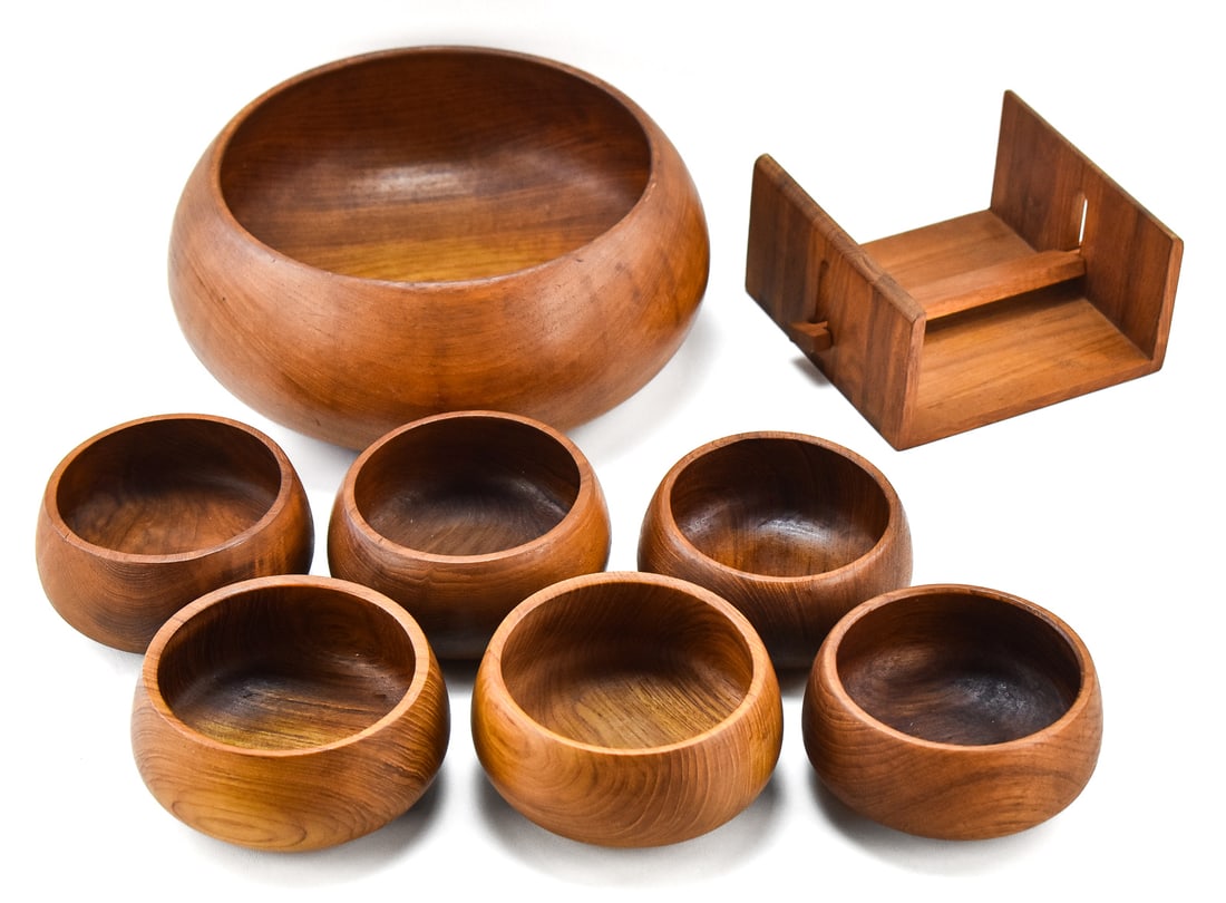 MID-CENTURY TEAK KALMAR SERVING BOWL SET & KALMAR TEAK NAPKIN HOLDER: Set of Kalmar teak serving bowls which includes one 5.5"H x 12"W x 12"D large serving bowl and six salad bowls. Also incudes one Kalmar teak napkin holder.