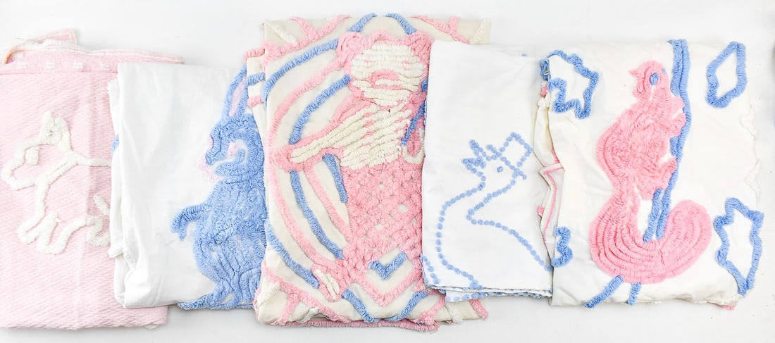 COLLECTION OF MID-CENTURY EMBROIDERED NURSING BLANKETS: A collection of Mid-century embroidered nursing blankets with blue and pink frills, most of which are twin sized and measure about 63" H x 44" W x 0.25" D.