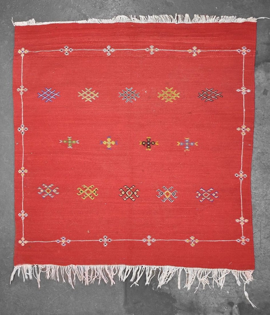 MOROCCAN WOOL KILIM RUG: A wool Moroccan Kilim rug with bright red coloring and geometric tribal patterns. The rug measures 43" L x 38" W.