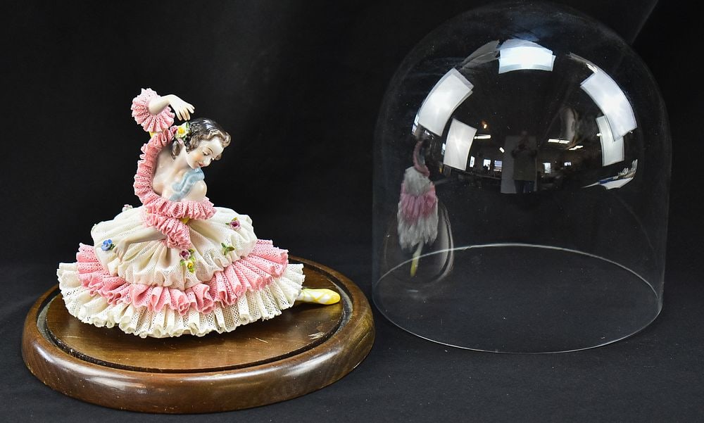 CASA FOR CHILDREN CHARITY LOT: VOLKSTEDT DRESDEN PORCELAIN LACE BALLERINA UNDER CLOCHE: A Volkstedt Dresden porcelain lace ballerina mounted to the base of a cloche, circa turn of the 19th century. The item measures 9" H, 8" W, 9" D. Proceeds from this lot benefit CASA For Children chari