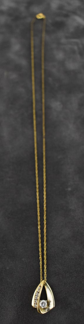 SIMON GOLUB & SONS 14K GOLD PENDANT WITH DIAMONDS ON A GOLD-FILLED CHAIN: A Simon Golub & Sons 14K gold pendant with a larger diamond, and six smaller diamonds. The pendant is marked 14k SGS. The pendant is hung on a gold filled chain measuring 18" in length. The pendan