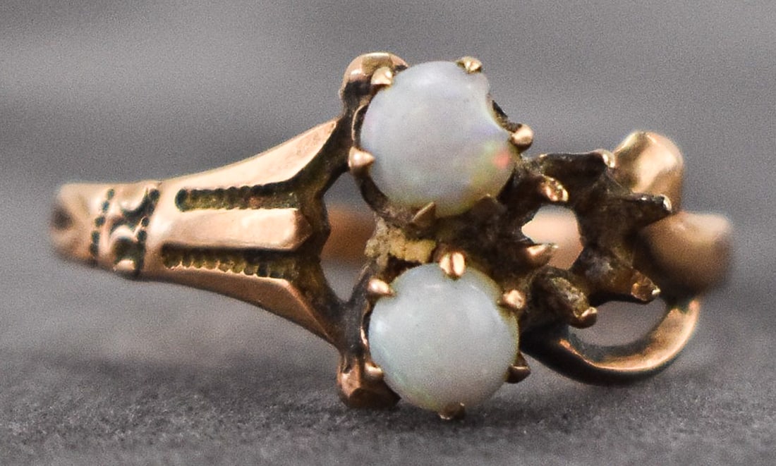 14K GOLD RING WITH OPALS: A 14K yellow gold ring with two cabochon opals and an empty setting. The ring is unmarked but professionally tested positive for 14K gold. The ring has a weight of 1.2 grams and is a size 6 U.S.