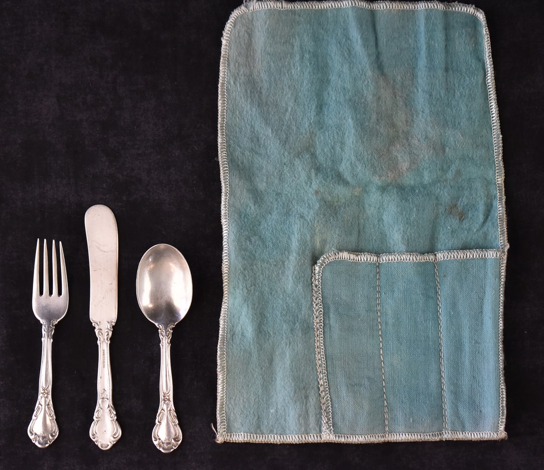 BIRKS 'CHANTILLY' STERLING SILVER 3-PIECE CHILD'S SILVERWARE SET: A Birks "Chantilly" pattern sterling silver three-piece child's silverware set, circa early 20th century. The set includes a small fork, small spoon, small butter knife, and a light blue Birks cloth