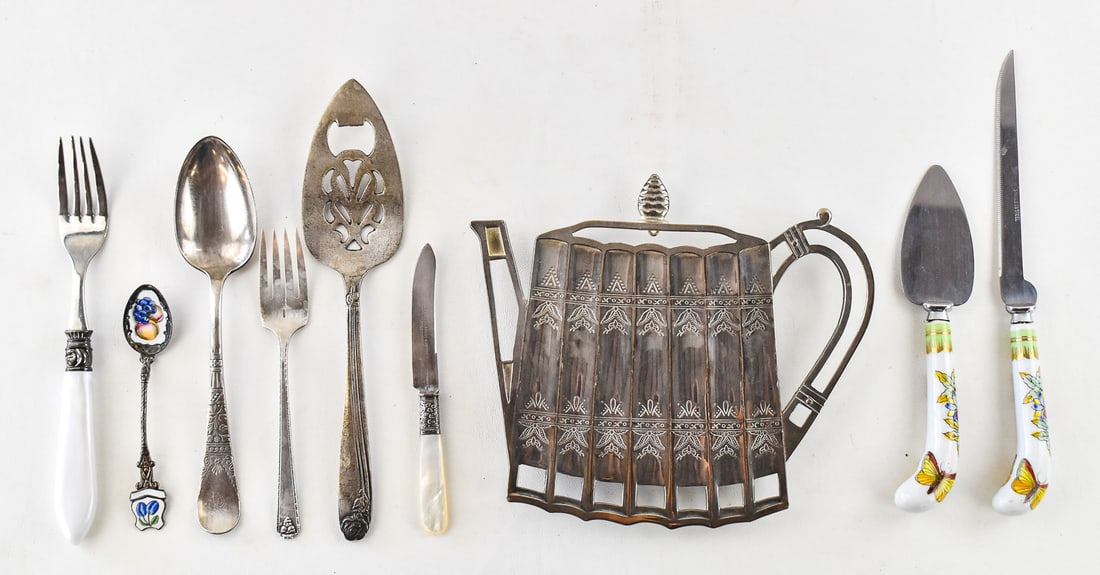 COLLECTION OF ANTIQUE SILVERPLATE SERVING UTENSILS & MORE: The collection of vintage and antique silverplate and stainless steel serving utensils some with porcelain handles and one with a mother of pearl handle. Also includes a vintage teapot shaped trivet m