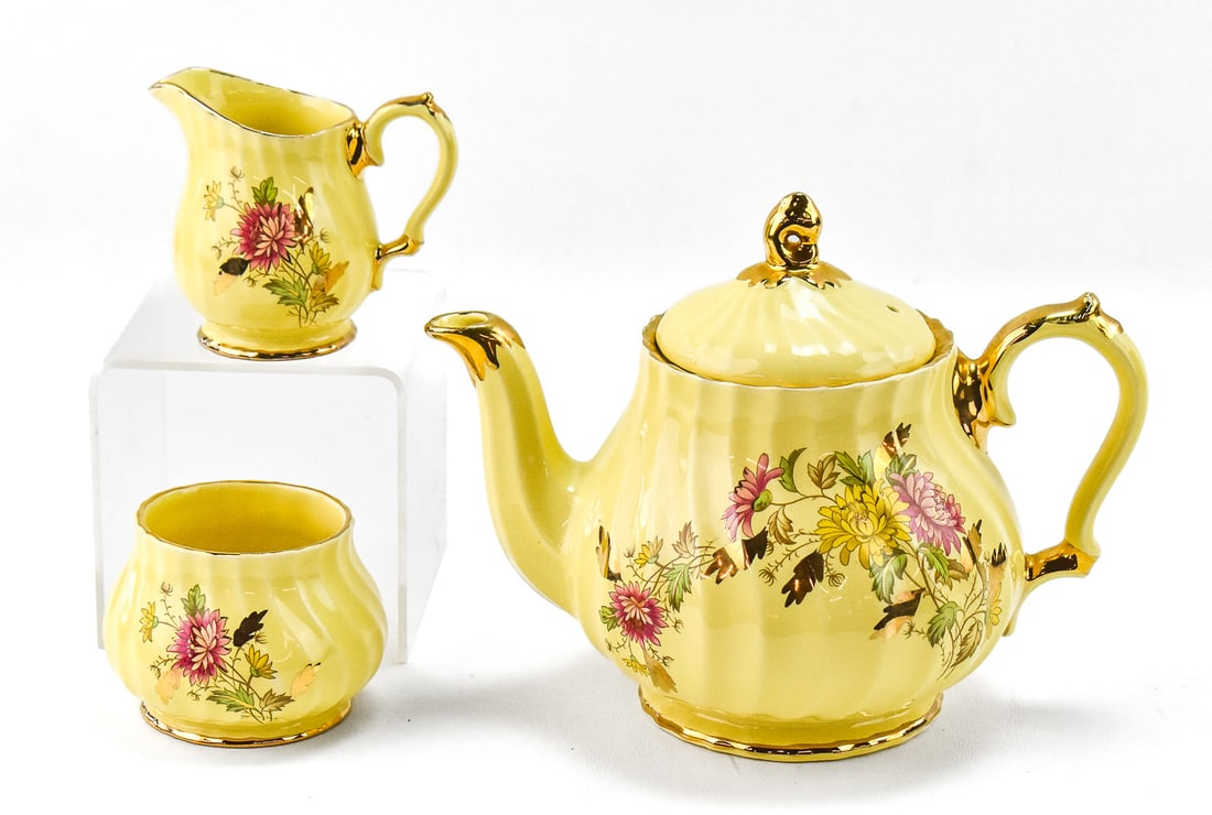 JAMES SADLER 'CHRYSANTHEMUM' TEAPOT, SUGAR BOWL, & CREAMER: A James Sadler "Chrysanthemum" pattern teapot, sugar bowl, and creamer circa 1930-1950s. The largest item measures 7" H, 8.5" W, 5.5" D.