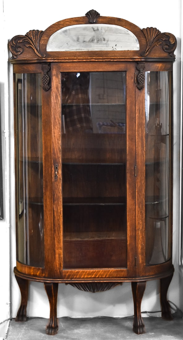 VICTORIAN OAK & GLASS CURIO CABINET: A Victorian oak and glass curio cabinet with claw feet and contains three shelves, circa turn of the 19th century. The item measures 67" H, 35" W, 13.5" D.