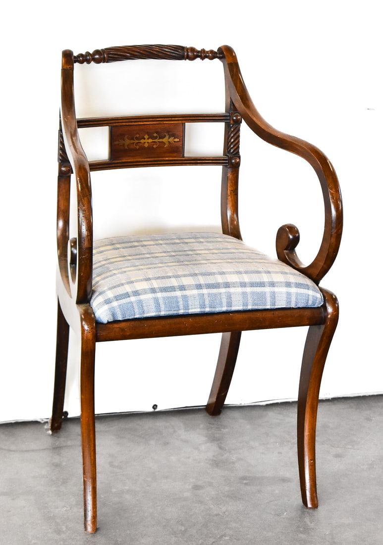 ENGLISH REGENCY REVIVAL BRASS INLAID BACK ARMCHAIR: An English Regency Revival period armchair with an ornate brass inlay on the back, circa 1940s. The chair measures 32.5" H x 20" W x 21" D.
