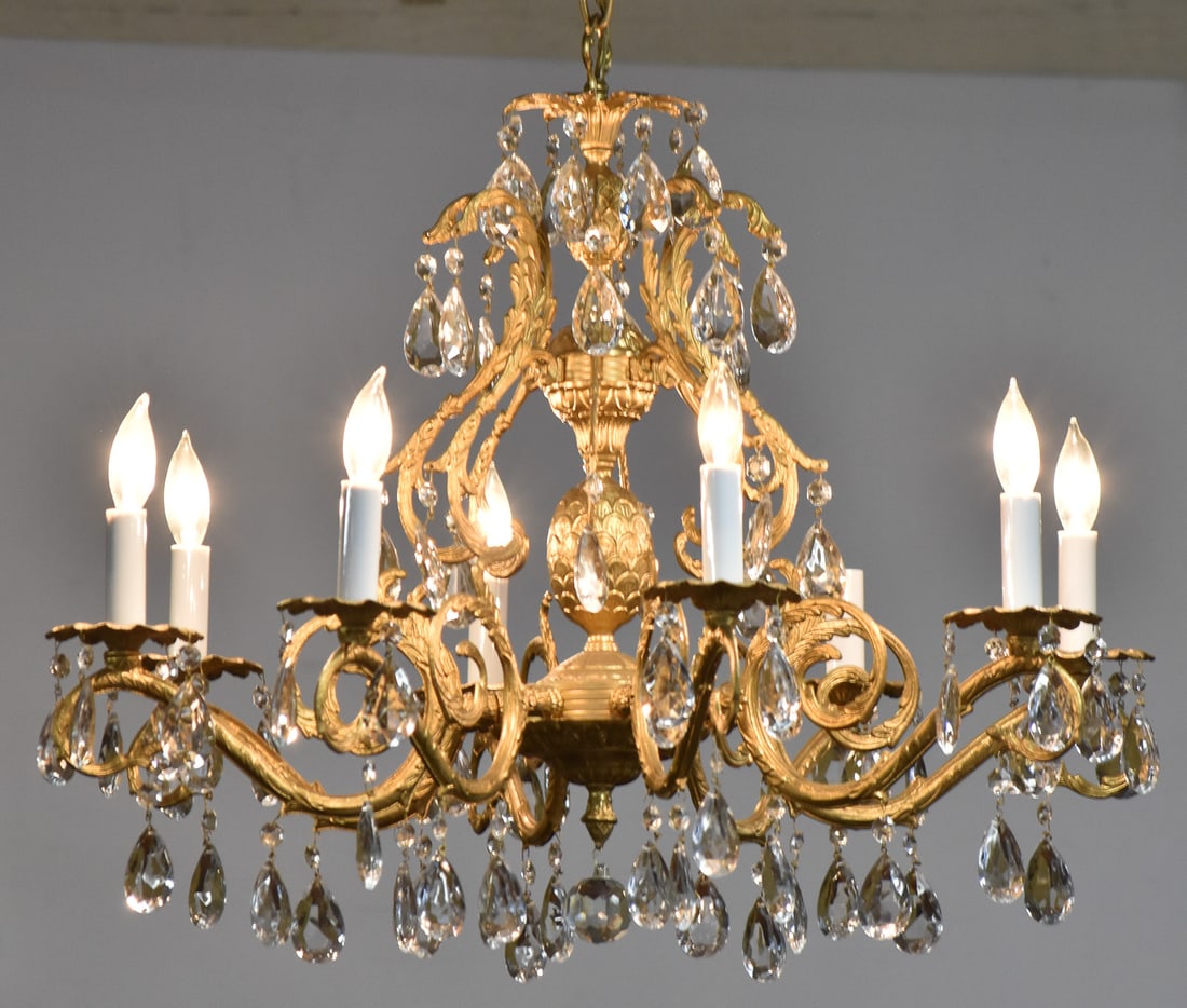 GILT PINEAPPLE DESIGN ELECTRIC EIGHT-LIGHT CANDLE CHANDELIER: A gilt pineapple design electric eight-light candle chandelier with Strass (attributed) crystal prisms, circa late 20th century. The item measures 17" H, 26.5" W, 26.5" D.