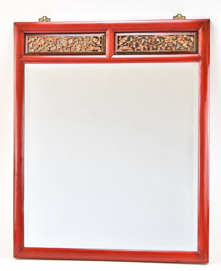 CHINESE RED LACQUER WALL MIRROR; EARLY 20TH CENTURY: A Chinese red lacquer wall mirror with gold gilt accents, circa early 20th century. The item measures 34.5"H x 28.25"W x 1"D.
