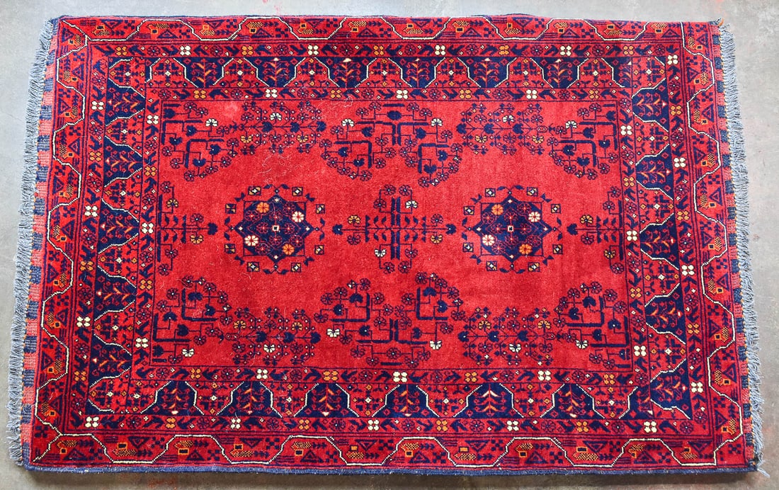 KUNDUZ AFGHAN WOOL RUG ON WOOD FRAME: A hand-knotted Kunduz Afghan wool rug with deep red and black colors using natural vegetable dyes. The rug is set on a wood frame so it can be displayed on the wall. The rug on the frame measures 40"