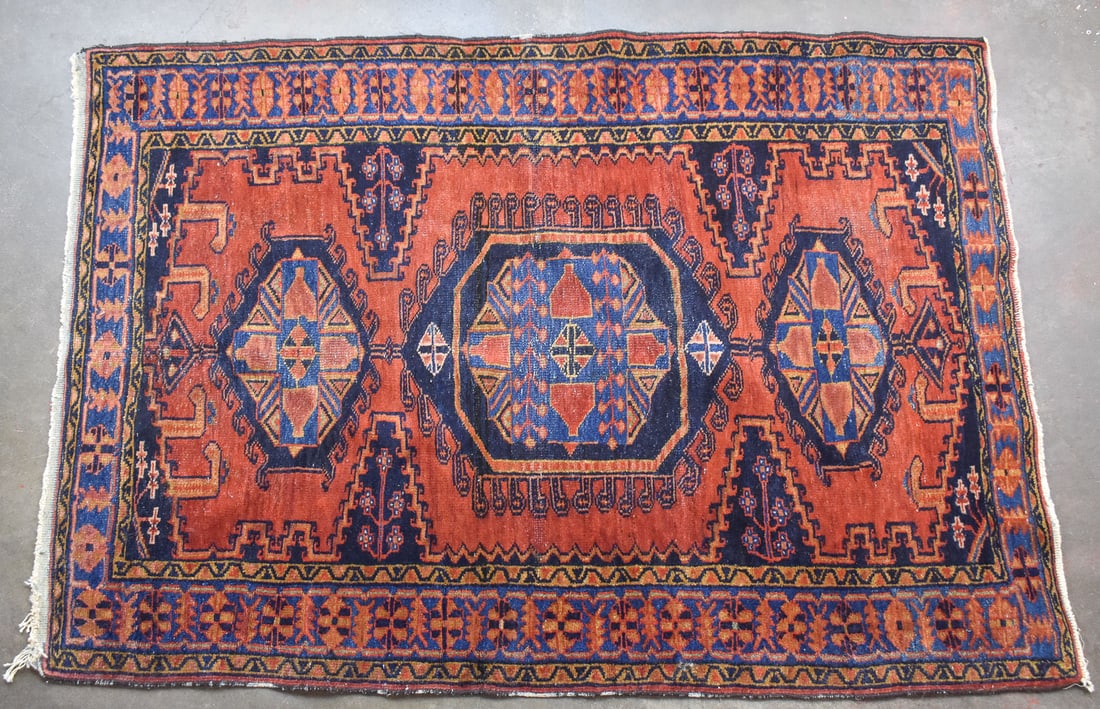 PERSIAN HAMADAN WOOL RUG: A Persian Hamadan wool rug with orange and blue colors, and tribal geometric patterns. The rug measures 60" L x 40" W.