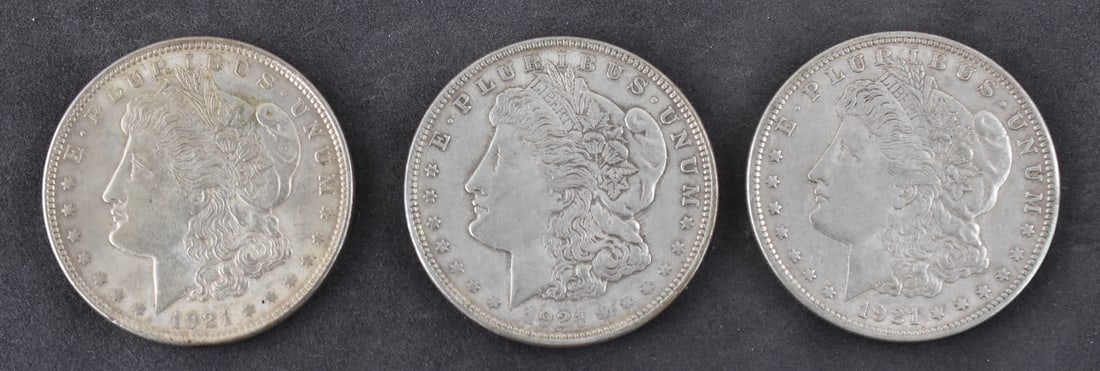 THREE 1921 MORGAN SILVER DOLLARS: Three 1921 U.S. Morgan silver dollars minted in Philadelphia. Each silver dollar is struck in 90% silver with each having a weight of approximately 26.7 grams.