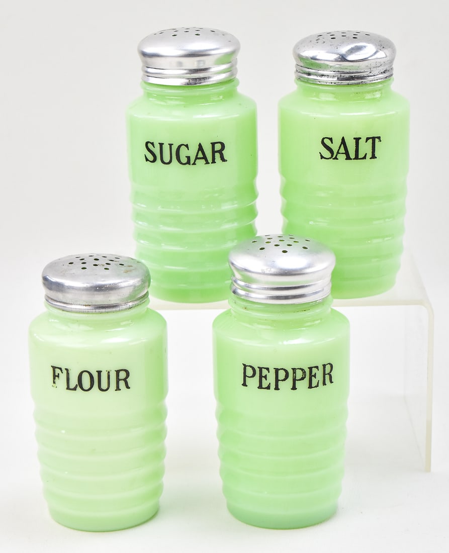 SMALL JADEITE RIBBED SHAKERS, JEANNETTE GLASS COMPANY: A set of four small Jadeite ribbed shaker canisters marked Flour, Sugar, Salt, and Pepper, produced by the Jeannette Glass Company, circa 1930s-1950s. Each canister measures 5" H x 2.25" W x 2.25" D.