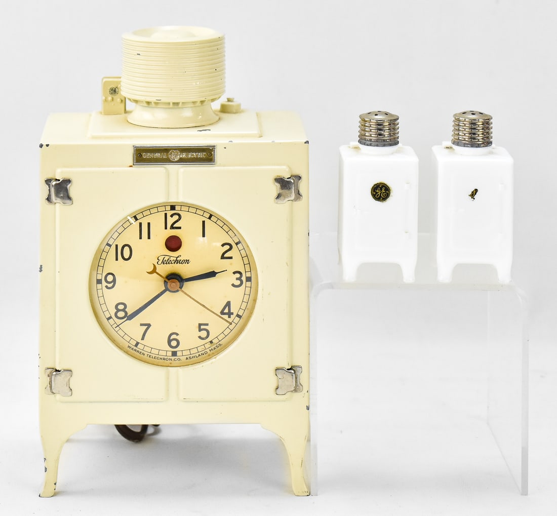 GENERAL ELECTRIC TELECHRON ELECTRIC CLOCK & SALT AND PEPPER SHAKERS: A collection of General Electric memorabilia items including a circa 1930 Telechron G.E. Monitor Top Refrigerator clock, and a pair of G.E. Refrigerator Salt and Pepper shakers circa 1925-1935. The
